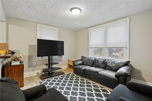 living room with a textured ceiling and light hardwood / wood-style floors