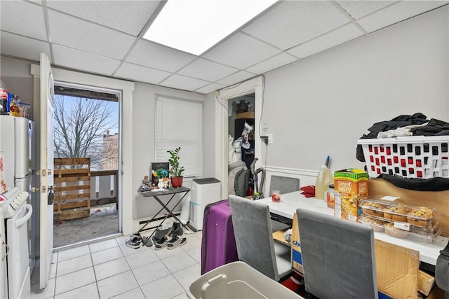 tiled dining space with a drop ceiling