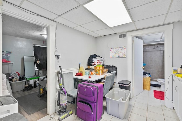 interior space with light tile patterned flooring and a paneled ceiling