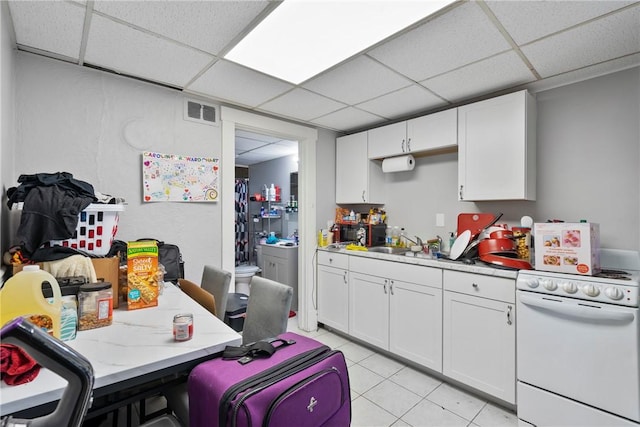 kitchen with a paneled ceiling, white cabinets, and white range with electric cooktop