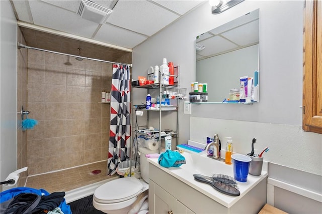 bathroom featuring vanity, a paneled ceiling, toilet, and walk in shower