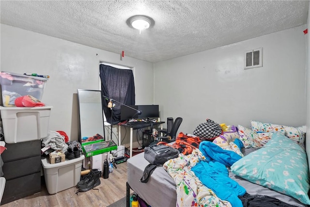 bedroom featuring wood-type flooring and a textured ceiling