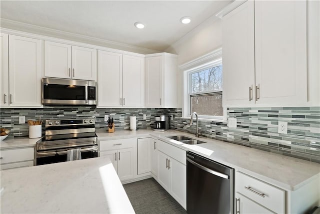 kitchen with sink, white cabinetry, tasteful backsplash, stainless steel appliances, and light stone countertops