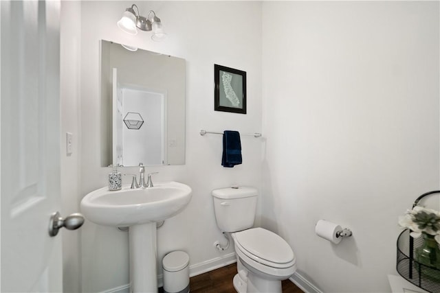 bathroom featuring hardwood / wood-style flooring and toilet