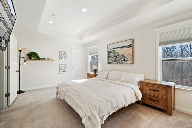 carpeted bedroom with ornamental molding, a raised ceiling, and multiple windows