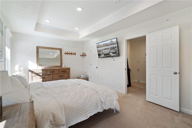 bedroom featuring light carpet, a closet, ornamental molding, and a raised ceiling