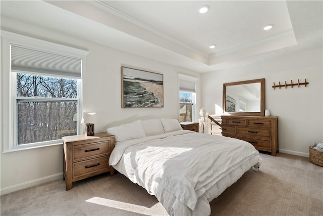 carpeted bedroom featuring ornamental molding and a tray ceiling