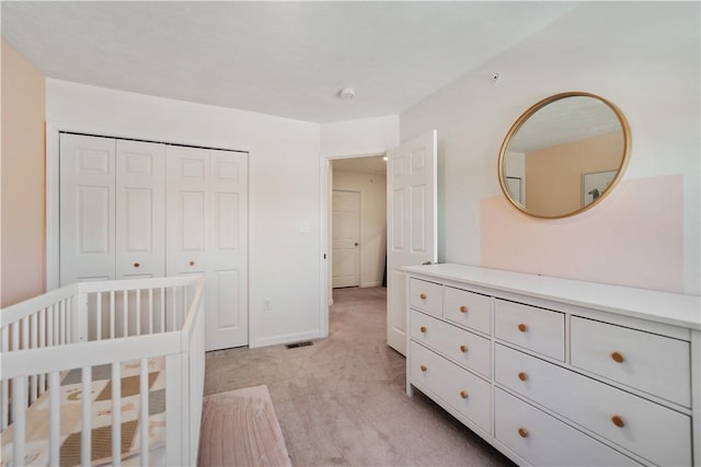 bedroom featuring light colored carpet and a closet