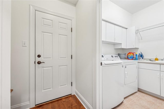 laundry area featuring cabinets, sink, and washer and dryer