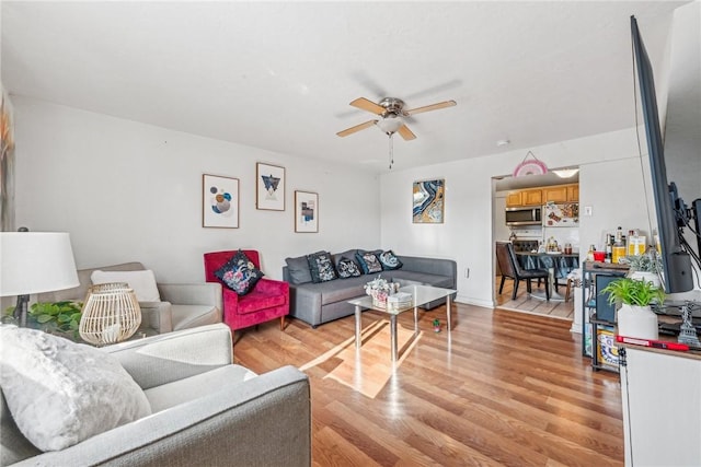 living room with ceiling fan and light wood-type flooring