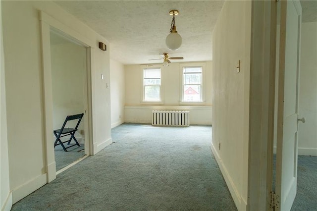 interior space with radiator, carpet floors, and a textured ceiling