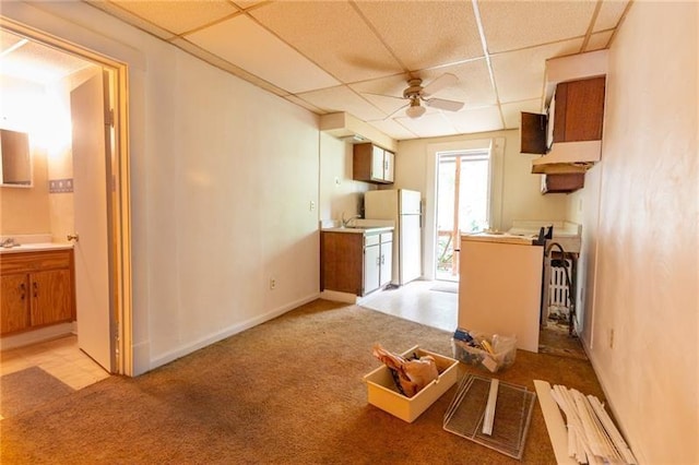 kitchen featuring light colored carpet, a paneled ceiling, fridge, and ceiling fan