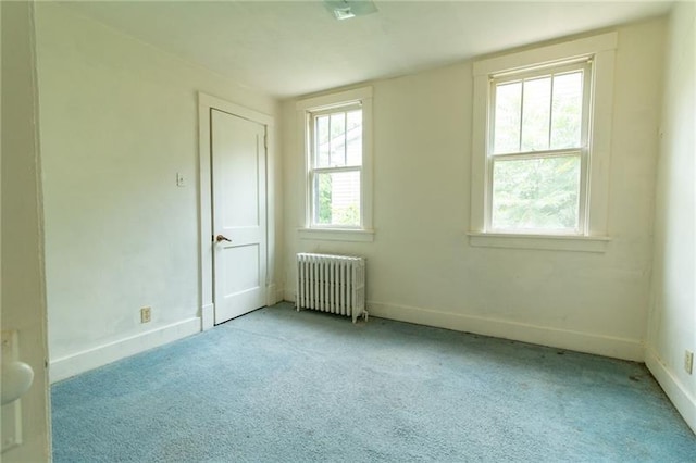 carpeted spare room featuring radiator