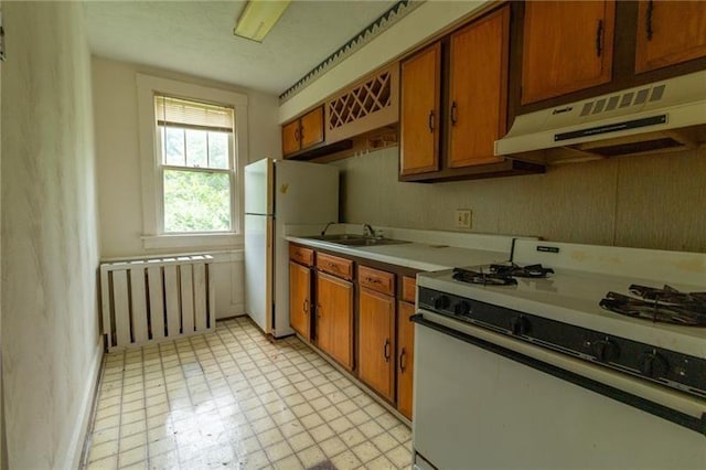 kitchen with sink, radiator, and white appliances