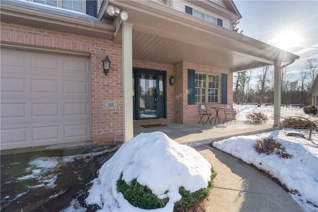 snow covered property entrance featuring a porch