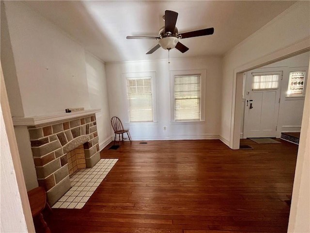 interior space with ceiling fan, dark wood-type flooring, and a fireplace