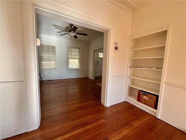 corridor with dark hardwood / wood-style flooring and built in features