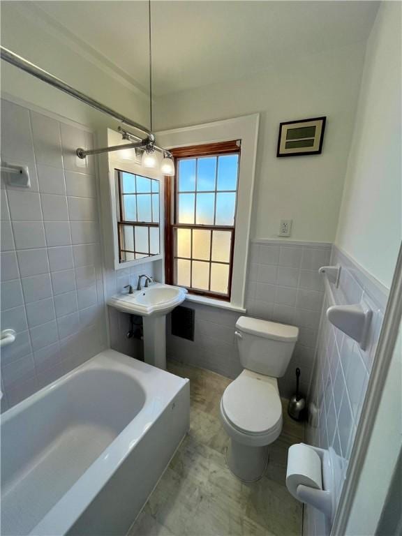 bathroom featuring tile walls, tiled shower / bath combo, and toilet