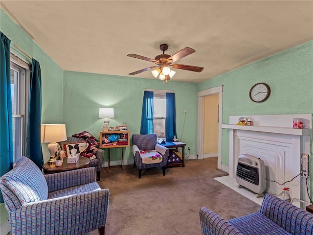 living room featuring heating unit, ceiling fan, and carpet