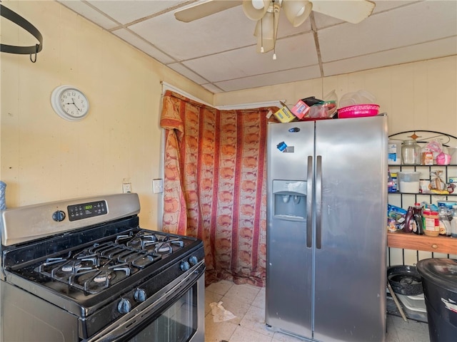 kitchen with ceiling fan, a paneled ceiling, stainless steel appliances, and light tile patterned floors