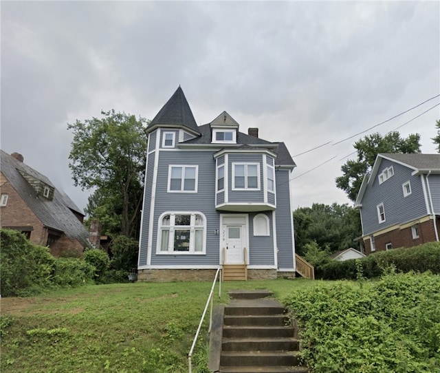 victorian-style house featuring a front lawn