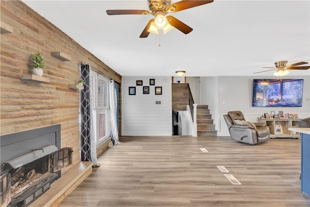 living room with light hardwood / wood-style flooring and ceiling fan