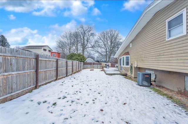 snowy yard featuring central air condition unit