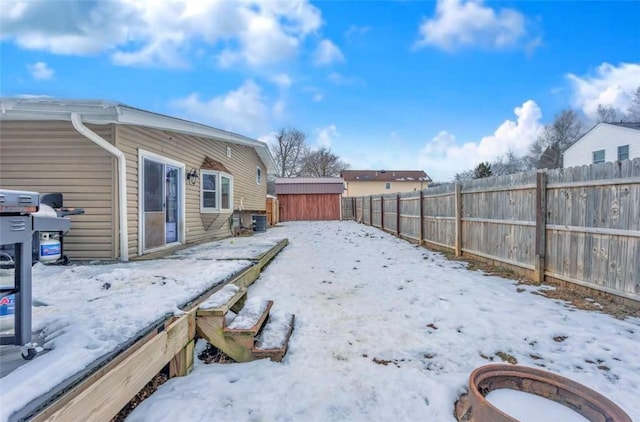 yard covered in snow with a shed and central air condition unit