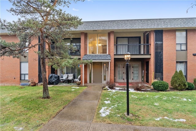 view of front of house featuring a front yard and a balcony