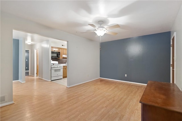 unfurnished living room with ceiling fan and light wood-type flooring