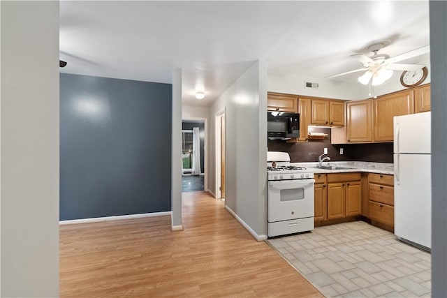 kitchen featuring sink, white appliances, ceiling fan, and light wood-type flooring