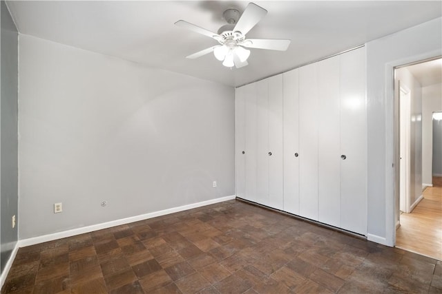 unfurnished bedroom featuring ceiling fan and a closet