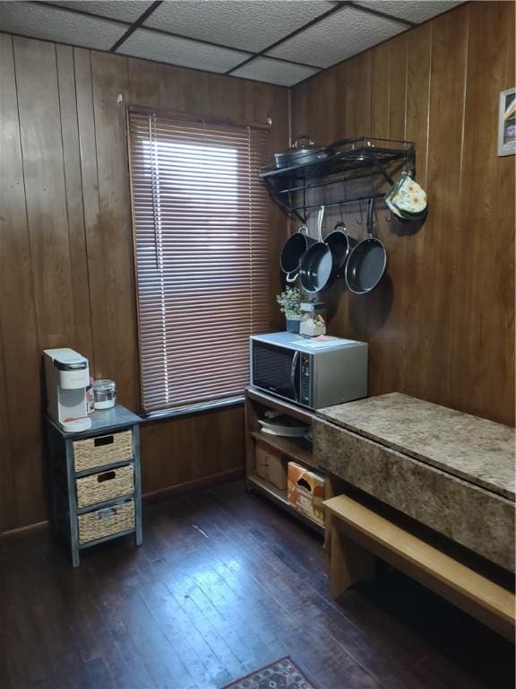 mudroom featuring dark wood-type flooring, a paneled ceiling, and wood walls