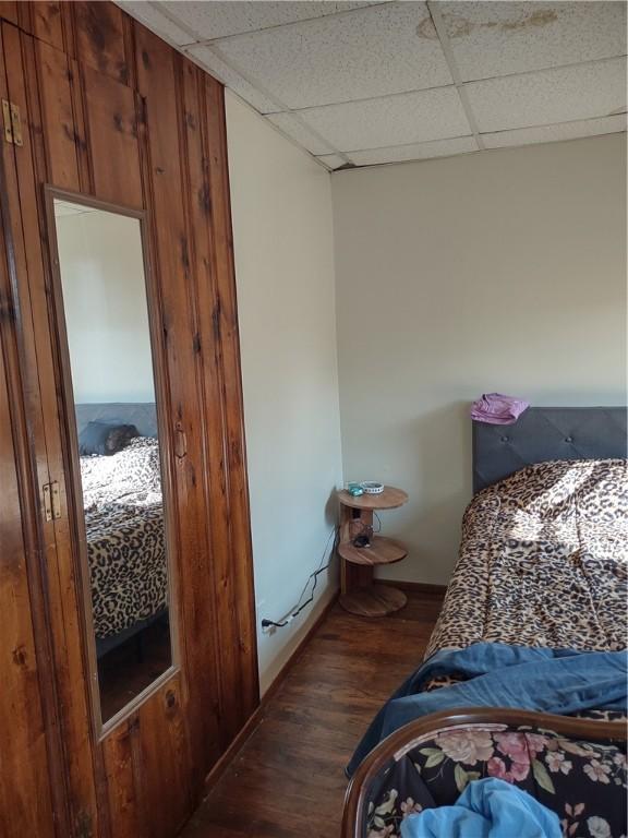 bedroom with dark hardwood / wood-style floors and a drop ceiling