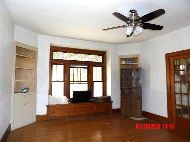 interior space with dark wood-type flooring and ceiling fan