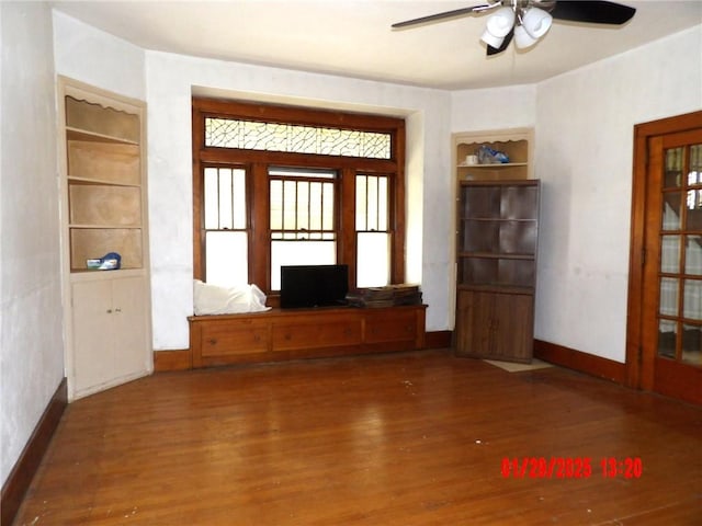 unfurnished living room with dark wood-type flooring and ceiling fan