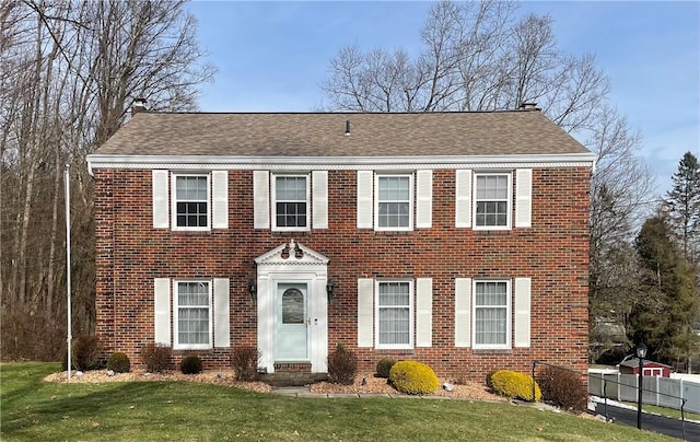 colonial home with a front lawn