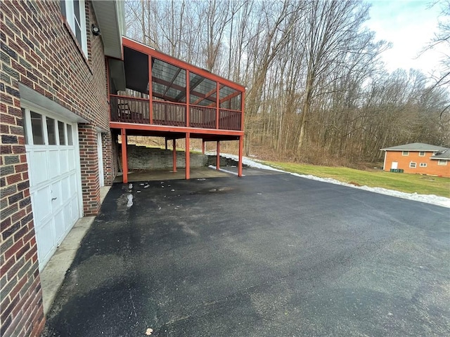 exterior space featuring a carport, a garage, and a sunroom