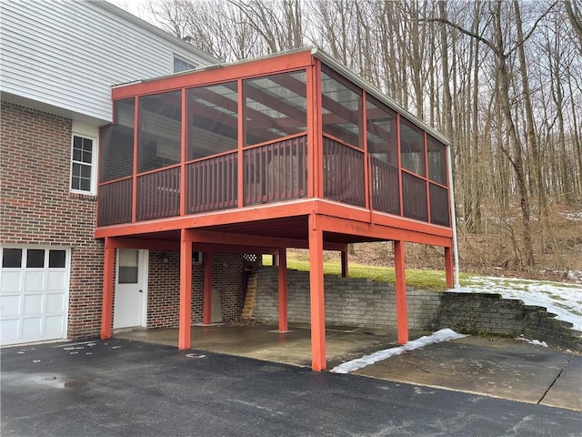 exterior space featuring a garage and a sunroom