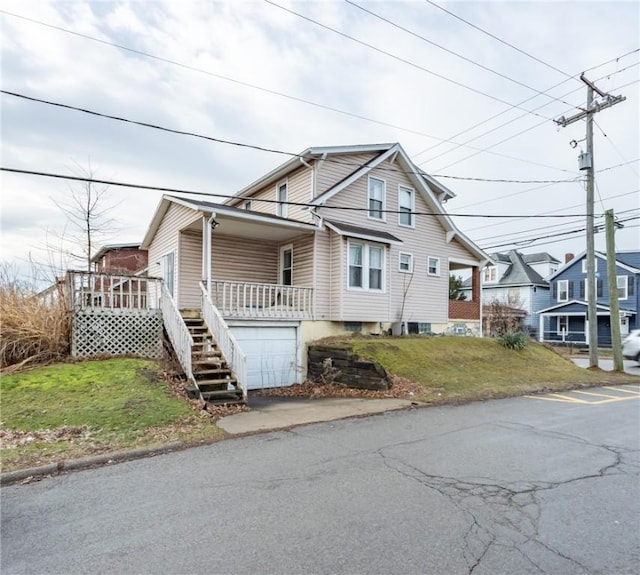 view of front of property featuring a garage, a porch, and a front lawn