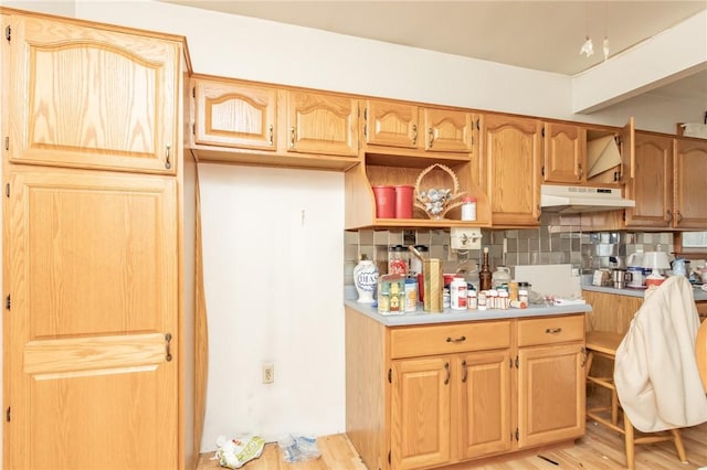 kitchen with light wood-type flooring and backsplash