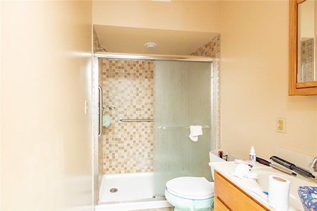 bathroom with vanity, a shower with shower door, and toilet