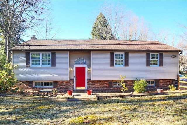 bi-level home with a front lawn and a chimney