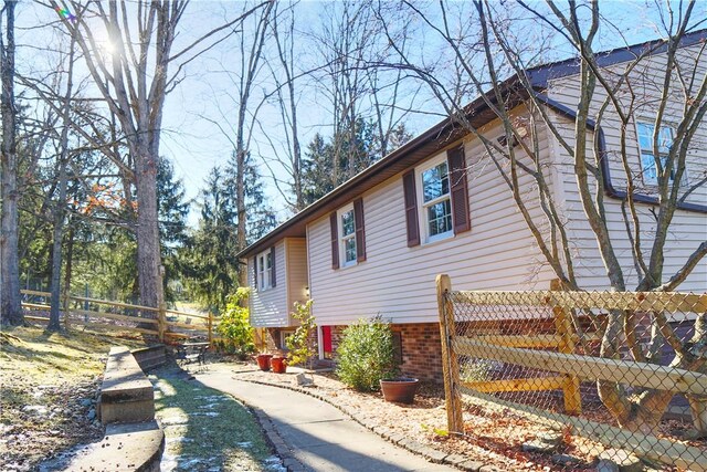 view of property exterior featuring brick siding and fence