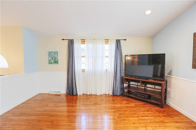 living room with wainscoting, wood finished floors, visible vents, and recessed lighting