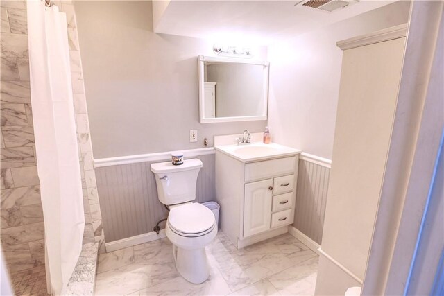 full bath with a wainscoted wall, marble finish floor, and toilet
