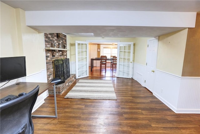 interior space featuring a fireplace, wainscoting, and wood finished floors