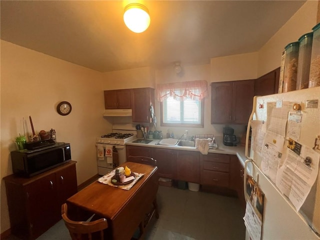 kitchen featuring dark brown cabinetry, sink, and white appliances