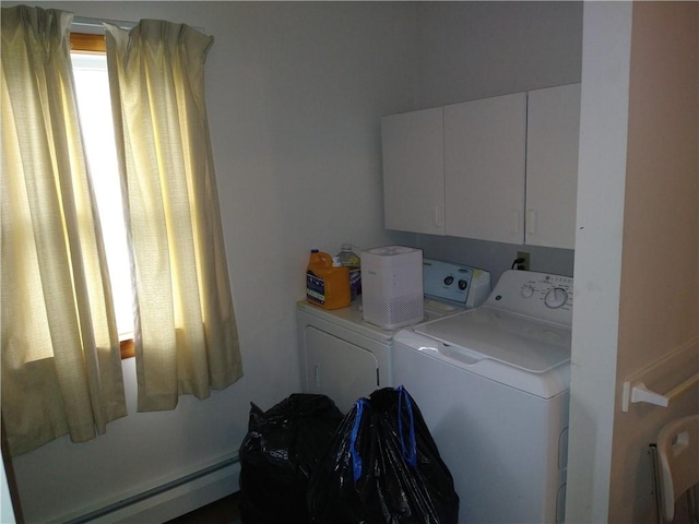 washroom with cabinets, washing machine and clothes dryer, and a baseboard heating unit