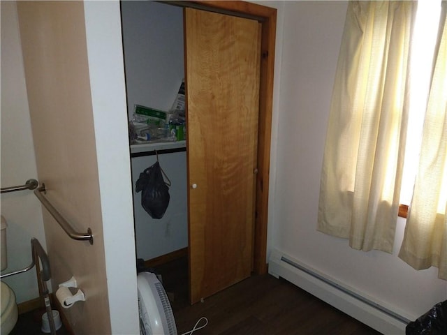 bathroom with toilet, hardwood / wood-style floors, and a baseboard heating unit